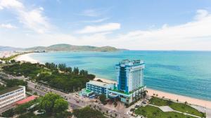 a building on the beach next to the ocean at Seagull Hotel in Quy Nhon