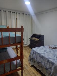 a bedroom with a bunk bed and a dresser at Casa temporada próximo a praça do canhão in São Pedro da Aldeia