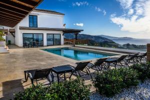a house with a swimming pool and chairs at Palacio de Cantalobos in Almuñécar