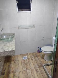 a bathroom with a toilet and a sink at Casa temporada próximo a praça do canhão in São Pedro da Aldeia +3 photos