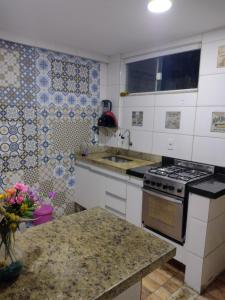 a kitchen with a sink and a stove top oven at Casa temporada próximo a praça do canhão in São Pedro da Aldeia
