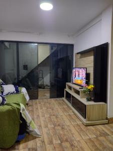 a living room with a flat screen tv and a couch at Casa temporada próximo a praça do canhão in São Pedro da Aldeia