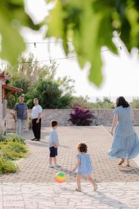 a woman and two children playing with a frisbee at Terra Hélios Suites & Studios in Kyparissia