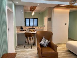 a living room with a chair and a kitchen at Muyeni BnB in Harare