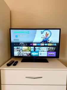 a flat screen tv sitting on top of a dresser at Comfortable rooms Manchester in Manchester +6 photos