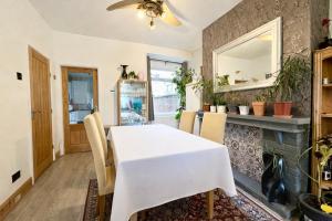a dining room with a white table and chairs at Comfortable rooms Manchester in Manchester