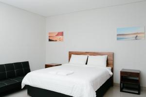 a bedroom with a white bed and a couch at Hau Batu Karas in Batukaras