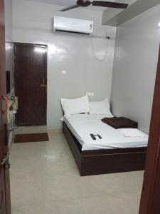 a small bed in a room with a door at ComfortInn in Chennai +20 photos