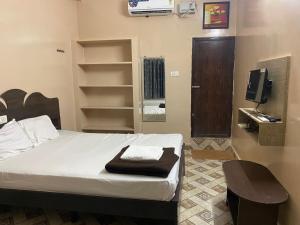 a bedroom with a bed and a tv and a mirror at ComfortInn in Chennai