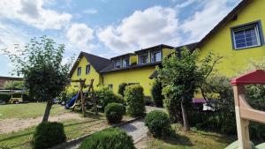 a yellow house with a playground in front of it at Ubytování U draka in Třeboň
