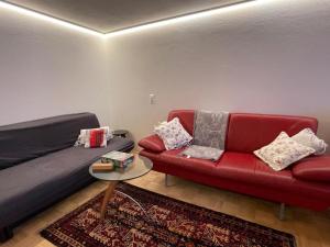 a living room with a red couch and a table at Beim Wiesbau‘r in Pichl bei Wels