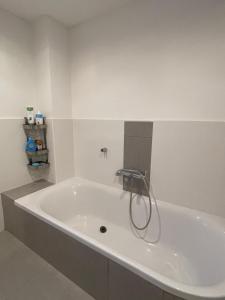 a white bath tub with a faucet in a bathroom at Beim Wiesbau‘r in Pichl bei Wels +21 photos