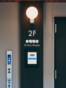 a sign on a door with a light on it at illi Nuto Shinjuku in Tokyo