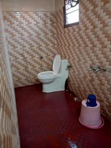 a bathroom with a toilet in a brick wall at ComfortInn in Chennai