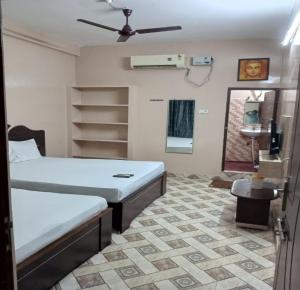 a bedroom with two beds and a ceiling fan at ComfortInn in Chennai