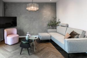 a living room with a couch and a chair at Slapen bij van O 2 in Yerseke