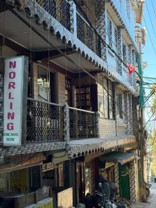 a building with a balcony and a sign on it at Bunk Stays in Darjeeling