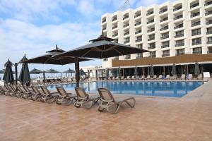 a row of chairs and umbrellas next to a swimming pool at Royal Mirage Agadir in Agadir