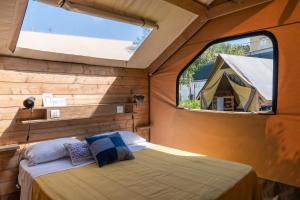 a bedroom with a bed and two windows at Procida Camp & Resort - Ciraccio in Procida