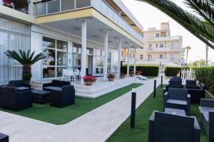 a patio at a hotel with chairs and tables at Hotel President in Alba Adriatica