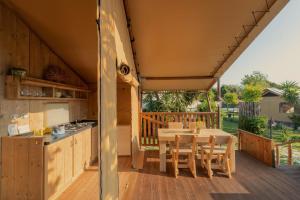 an outdoor kitchen with a table and chairs on a deck at Procida Camp & Resort - Ciraccio in Procida +127 photos