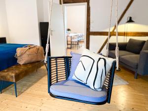 a swing chair with a pillow in a living room at WEINQUARTIER Naumburg 6 Apartments Eventraum Fahrradraum Kaffee Küche Parken in Naumburg