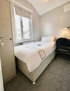 a bedroom with a bed with a window and a chair at Comfortable rooms Manchester in Manchester