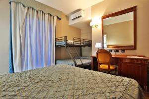 a hotel room with a bed and a desk and a mirror at Hotel La Fayette Giugliano Licola in Giugliano in Campania