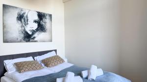 a bedroom with a bed and a painting on the wall at Zapisane w Cegle by LibertaRent in Świdnica