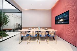 a dining room with a table and a tv on a wall at Echarm International Hotel Guangzhou Huangpu Flagship Shuixi Subway Station Branch - Free Deliver Service to Guangzhou Baiyun International Airport & Free Deliver Service to Canton Fair Complex During Canton Fair Period in Guangzhou +48 photos