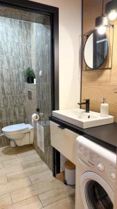 a bathroom with a washing machine and a sink at Zapisane w Cegle by LibertaRent in Świdnica