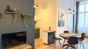 a living room with a table and a kitchen at Zapisane w Cegle by LibertaRent in Świdnica