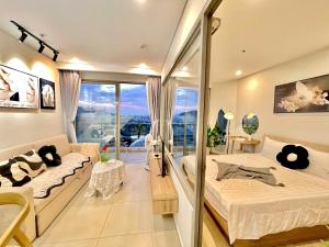 a bedroom with a bed and a couch at The Sóng Vung Tau Apartment - Pool Near Sea in Vung Tau
