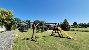 a playground with a yellow slide in a field at Ubytování Mája in Třeboň