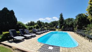 a swimming pool with lounge chairs and a swimming pool at Ubytování Mája in Třeboň +22 photos