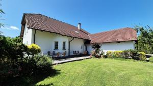 a white house with a grass yard in front of it at Ubytování Mája in Třeboň
