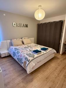 a bedroom with a bed with a dream sign on the wall at La Bulle d Avenir in Corcieux