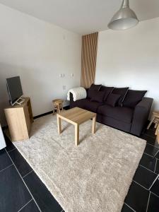 a living room with a couch and a table at La Bulle d Avenir in Corcieux