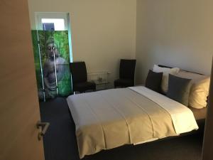 a hotel room with a bed and two chairs at Gutunterdachgebracht in Langerwehe