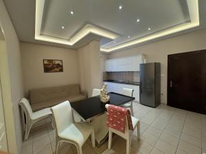 a kitchen with a table and chairs and a couch at Hotel Dragoi in Velipojë