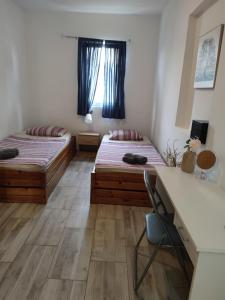 two beds in a room with a desk and a desk at Music Vir Apartment in Vir +28 photos