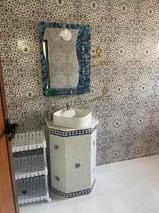 a bathroom with a sink and a mirror at Villa haut standing vue mere in Kenitra