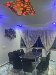 a dining room with purple curtains and a table and chairs at Villa haut standing vue mere in Kenitra