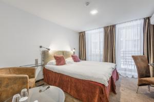 a hotel room with a bed and a table and chairs at HOF Apartments in Kaunas
