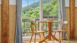 a table and chairs in front of a large window at Daecheon Ocean Forest Pension in Boryeong +1 photo