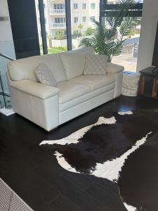 a white couch sitting in a living room with a rug at Mount Views in Mount Maunganui