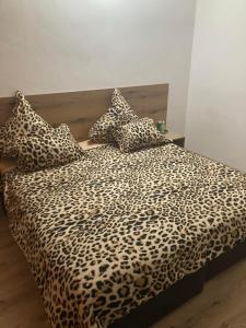 a bed with a leopard print blanket and pillows at Casa De Zambini in Plovdiv