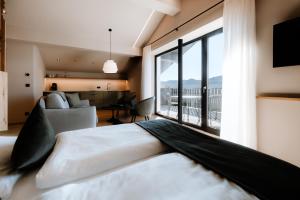 a bedroom with a large bed and a large window at Stricker Aparthotel in Tirolo +42 photos