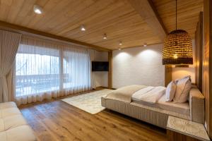 a bedroom with a large bed and a large window at Prispa Premium Resort in Vişeu de Sus