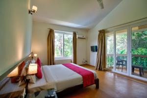 a bedroom with a bed and a large window at Aveeno Resort with Swimming Pool and Jacuzzi Near Calangute and Baga in Sangolda